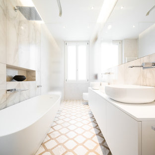 Immagine di un'ampia stanza da bagno padronale design con ante lisce, ante bianche, piastrelle bianche, piastrelle di marmo, pareti bianche, pavimento in marmo, lavabo a bacinella, pavimento bianco, top bianco e vasca freestanding