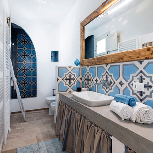 Esempio di una stanza da bagno con doccia mediterranea con nessun'anta, doccia alcova, WC monopezzo, piastrelle blu, pareti bianche, lavabo da incasso, top in cemento, pavimento beige, doccia aperta e top grigio