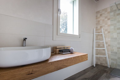 Cette photo montre une salle d'eau tendance en bois vieilli avec une douche ouverte, WC suspendus, un carrelage beige, des carreaux de céramique, un mur beige, un sol en carrelage de porcelaine, une vasque et un plan de toilette en bois.