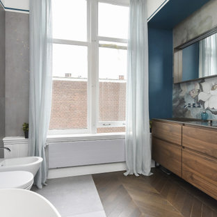 Ispirazione per una stanza da bagno padronale design con ante lisce, ante in legno scuro, vasca freestanding, WC sospeso, piastrelle di cemento, pareti multicolore, pavimento con piastrelle effetto legno, lavabo sottopiano, pavimento marrone, top nero, un lavabo, mobile bagno sospeso e carta da parati