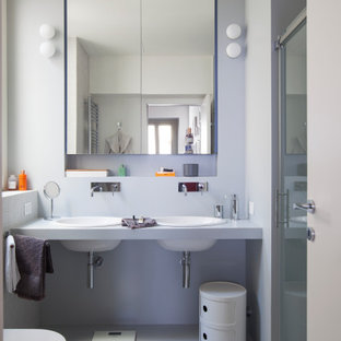 Immagine di un'in muratura stanza da bagno padronale minimal di medie dimensioni con doccia alcova, WC sospeso, piastrelle grigie, piastrelle in gres porcellanato, pareti grigie, pavimento in gres porcellanato, lavabo da incasso, pavimento grigio, top grigio, due lavabi e porta doccia a battente