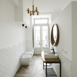 Foto di un'ampia stanza da bagno con doccia industriale con ante lisce, ante bianche, doccia a filo pavimento, WC monopezzo, piastrelle bianche, piastrelle in gres porcellanato, pareti bianche, pavimento in gres porcellanato, top in legno, pavimento marrone, doccia aperta, lavabo a consolle e top marrone