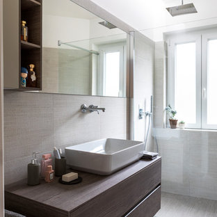 Esempio di una stanza da bagno contemporanea con ante lisce, ante in legno bruno, doccia a filo pavimento, piastrelle beige, piastrelle grigie, pareti bianche, lavabo a bacinella, top in legno, pavimento beige e top marrone