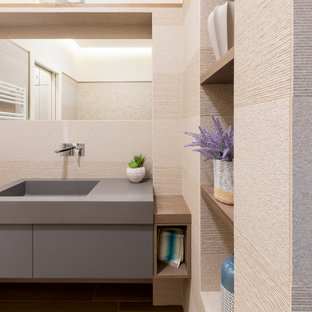Foto di una stanza da bagno con doccia minimal di medie dimensioni con ante a filo, ante grigie, WC sospeso, piastrelle beige, piastrelle in gres porcellanato, pareti beige, pavimento in gres porcellanato, lavabo integrato, top in superficie solida, top grigio, nicchia, un lavabo e mobile bagno sospeso