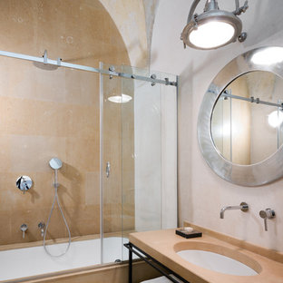 Diseño de cuarto de baño mediterráneo con armarios abiertos, bañera encastrada sin remate, combinación de ducha y bañera, baldosas y/o azulejos beige, paredes blancas, lavabo bajoencimera, ducha con puerta corredera y encimeras beige