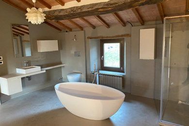 Ispirazione per una stanza da bagno con doccia industriale di medie dimensioni con ante lisce, ante beige, WC monopezzo, pareti grigie, pavimento in cemento, lavabo a bacinella, top in superficie solida, pavimento grigio e top beige