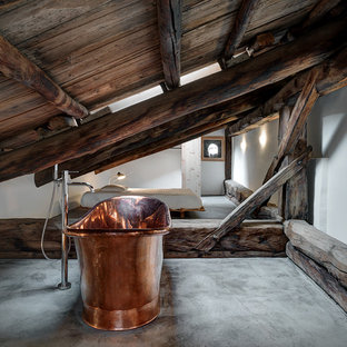 Esempio di una grande stanza da bagno padronale rustica con vasca freestanding, pareti bianche, pavimento in cemento e pavimento grigio