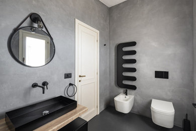 Immagine di una stanza da bagno con doccia minimalista con ante nere, WC sospeso, pareti grigie, lavabo rettangolare, un lavabo e mobile bagno sospeso