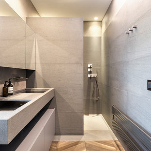 Immagine di una stanza da bagno con doccia contemporanea con ante grigie, piastrelle grigie, lavabo integrato, top grigio, zona vasca/doccia separata, pavimento grigio e doccia aperta