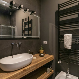 Immagine di una stanza da bagno con doccia contemporanea di medie dimensioni con nessun'anta, ante in legno chiaro, WC sospeso, piastrelle grigie, pareti grigie, pavimento in gres porcellanato, lavabo a bacinella, top in legno, pavimento grigio e top beige