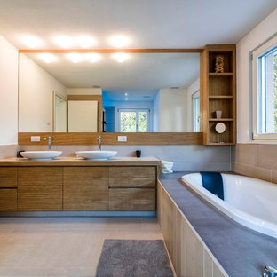 Esempio di una stanza da bagno design con lavabo a bacinella, ante lisce, ante in legno scuro, vasca da incasso e pareti bianche