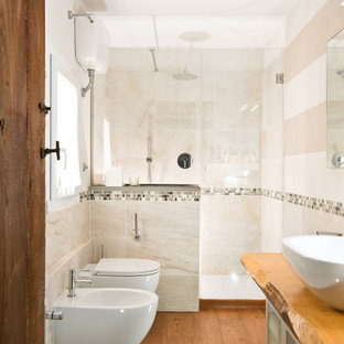 Foto di una piccola stanza da bagno con doccia mediterranea con ante di vetro, ante bianche, WC sospeso, piastrelle beige, piastrelle in ceramica, pareti bianche, lavabo a bacinella, pavimento marrone, mobile bagno freestanding, doccia alcova, pavimento in legno massello medio, top in legno, top marrone e un lavabo