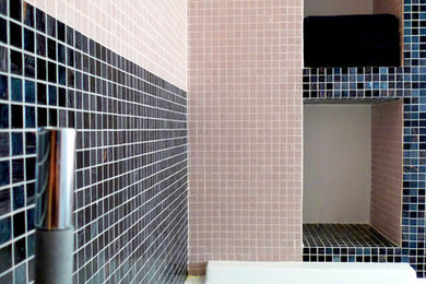 Foto di una stanza da bagno padronale moderna di medie dimensioni con nessun'anta, ante nere, vasca da incasso, WC monopezzo, piastrelle rosa, piastrelle a mosaico, pareti rosa, pavimento in gres porcellanato, lavabo a colonna, top in superficie solida e pavimento nero