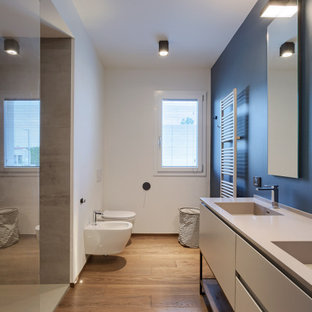 Esempio di una grande stanza da bagno con doccia minimal con consolle stile comò, ante grigie, doccia alcova, WC sospeso, pareti bianche, pavimento in legno massello medio, lavabo integrato, pavimento beige e top grigio