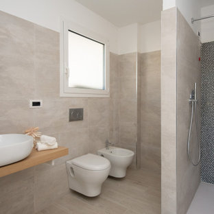 Foto di una stanza da bagno con doccia minimal di medie dimensioni con nessun'anta, doccia a filo pavimento, WC sospeso, piastrelle beige, lavabo a bacinella, piastrelle in gres porcellanato, pareti bianche, pavimento in gres porcellanato, top in legno, pavimento beige e top beige