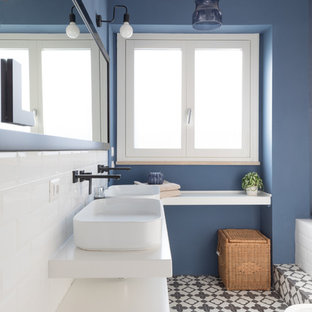 Esempio di una stanza da bagno contemporanea con ante lisce, ante bianche, bidè, piastrelle bianche, piastrelle diamantate, pareti blu, lavabo a bacinella, pavimento multicolore e top bianco