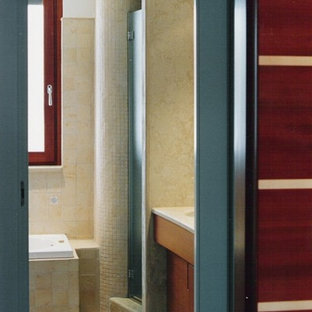 Mittelgroßes Modernes Badezimmer En Suite mit flächenbündigen Schrankfronten, dunklen Holzschränken, Einbaubadewanne, Nasszelle, Wandtoilette mit Spülkasten, beigefarbenen Fliesen, Terrakottafliesen, beiger Wandfarbe, Kalkstein, Unterbauwaschbecken, Kalkstein-Waschbecken/Waschtisch, beigem Boden und Falttür-Duschabtrennung in Bari