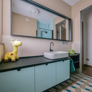 Idee per una piccola stanza da bagno per bambini contemporanea con ante lisce, piastrelle beige, piastrelle in gres porcellanato, pareti beige, pavimento in cementine, lavabo a bacinella, top in superficie solida, pavimento multicolore, top nero e ante blu