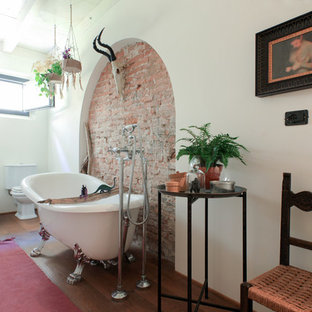 Ispirazione per una stanza da bagno padronale mediterranea con vasca con piedi a zampa di leone, WC a due pezzi, doccia alcova, pareti beige, parquet scuro e pavimento marrone
