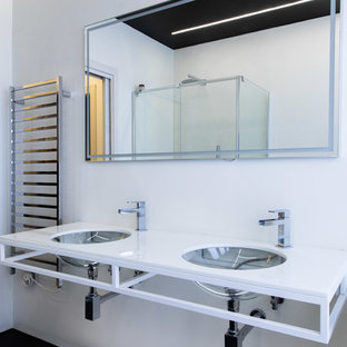 Idee per una stanza da bagno moderna con pareti bianche, lavabo sottopiano, pavimento nero e top bianco