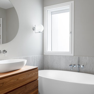 Esempio di una stanza da bagno con doccia design con ante lisce, ante in legno bruno, vasca freestanding, piastrelle grigie, pareti grigie, lavabo a bacinella, top in legno e top marrone