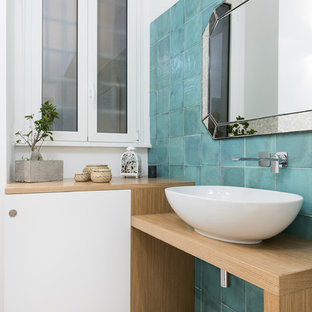 Esempio di una stanza da bagno con doccia minimal di medie dimensioni con ante lisce, ante in legno chiaro, bidè, pareti blu, lavabo a bacinella, top in legno, pavimento grigio, piastrelle blu e top beige