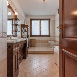 Idee per una stanza da bagno con doccia mediterranea con ante con bugna sagomata, ante in legno bruno, bidè, pareti beige, pavimento beige e lavabo da incasso