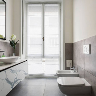 Ispirazione per una piccola stanza da bagno contemporanea con ante lisce, ante bianche, bidè, pareti bianche, lavabo a bacinella, pavimento grigio e top bianco