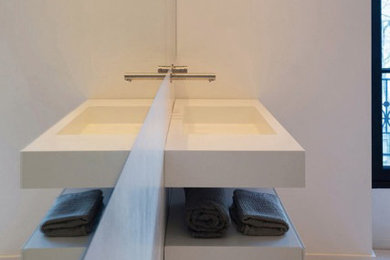 Ejemplo de cuarto de baño principal contemporáneo con puertas de armario grises, paredes blancas, lavabo suspendido y encimera de cemento