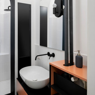 Foto di una stanza da bagno con doccia scandinava di medie dimensioni con ante in stile shaker, doccia aperta, WC sospeso, piastrelle bianche, piastrelle in ceramica, pareti bianche, pavimento in gres porcellanato, lavabo a bacinella, top in vetro, pavimento nero, doccia aperta, top nero, nicchia, un lavabo e mobile bagno freestanding