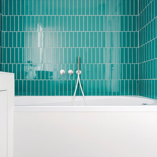 Immagine di una piccola stanza da bagno per bambini minimal con ante lisce, ante bianche, vasca ad alcova, piastrelle blu, piastrelle verdi, piastrelle in gres porcellanato, pareti bianche, pavimento in gres porcellanato, top in superficie solida, pavimento bianco, top bianco, vasca/doccia e doccia aperta
