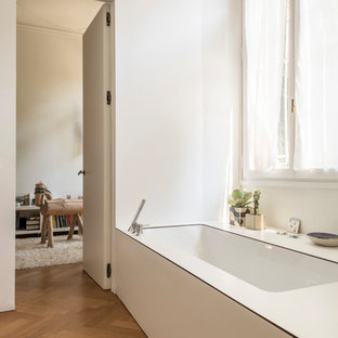 Ispirazione per una piccola stanza da bagno padronale scandinava con pavimento in legno massello medio, top in laminato, top bianco, vasca sottopiano, pareti bianche e pavimento marrone