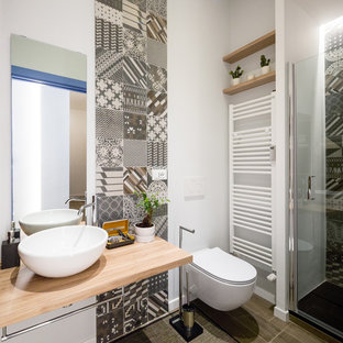 Immagine di una piccola stanza da bagno con doccia contemporanea con nessun'anta, ante in legno chiaro, top in legno, WC sospeso, piastrelle grigie, pareti bianche, lavabo a bacinella, pavimento grigio, porta doccia a battente e top marrone