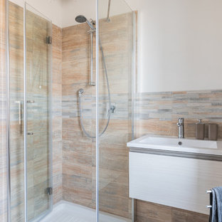 Immagine di una piccola stanza da bagno con doccia minimal con ante lisce, ante in legno chiaro, doccia ad angolo, WC a due pezzi, piastrelle multicolore, piastrelle in gres porcellanato, pareti bianche, pavimento in gres porcellanato, lavabo integrato, pavimento beige e porta doccia scorrevole