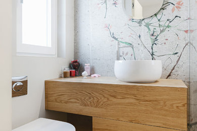 Ispirazione per una piccola stanza da bagno padronale minimalista con doccia a filo pavimento, WC sospeso, parquet chiaro, lavabo a bacinella, top in legno e porta doccia a battente