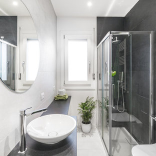 Immagine di una piccola stanza da bagno con doccia contemporanea con ante bianche, WC sospeso, piastrelle grigie, pistrelle in bianco e nero, piastrelle in ceramica, pareti bianche, lavabo a bacinella, doccia ad angolo, pavimento con piastrelle in ceramica, top in granito, pavimento bianco e porta doccia scorrevole