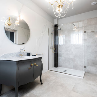 Esempio di una stanza da bagno boho chic con piastrelle bianche, piastrelle in gres porcellanato, pareti bianche, pavimento in gres porcellanato, pavimento grigio, porta doccia a battente, consolle stile comò, ante nere, doccia ad angolo, lavabo sottopiano, top in marmo e top grigio
