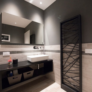 Ispirazione per una stanza da bagno con doccia minimal di medie dimensioni con nessun'anta, ante nere, piastrelle grigie, pareti grigie, lavabo a bacinella, pavimento beige e top nero