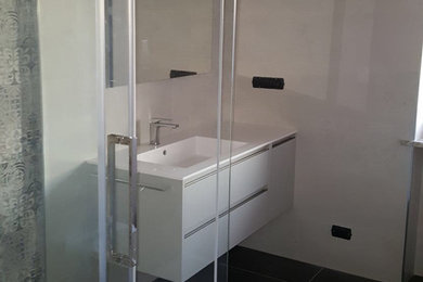 Ispirazione per una stanza da bagno con doccia contemporanea di medie dimensioni con ante lisce, ante beige, doccia a filo pavimento, WC a due pezzi, piastrelle bianche, piastrelle in gres porcellanato, pareti bianche, pavimento in gres porcellanato, lavabo integrato, top in quarzite, pavimento grigio e porta doccia scorrevole