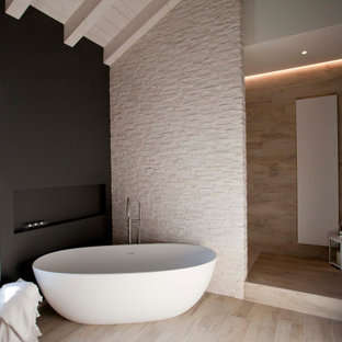 Immagine di una grande stanza da bagno padronale design con vasca freestanding, piastrelle beige, pareti nere e pavimento beige