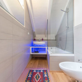 Immagine di una stanza da bagno boho chic con WC sospeso, pareti beige, pavimento in legno massello medio, pavimento beige, nessun'anta, ante bianche, vasca ad angolo, vasca/doccia, piastrelle grigie, lavabo a bacinella e doccia aperta