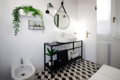 ヴェネツィアにあるお手頃価格の小さな北欧スタイルのおしゃれなバスルーム (浴槽なし) (黒いキャビネット、コーナー設置型シャワー、分離型トイレ、白いタイル、セラミックタイル、白い壁、セメントタイルの床、ベッセル式洗面器、白い床、引戸のシャワー) の写真