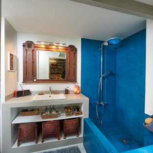 Esempio di una stanza da bagno padronale mediterranea di medie dimensioni con nessun'anta, ante grigie, top in cemento, top grigio, vasca/doccia, piastrelle blu, pareti bianche e lavabo da incasso
