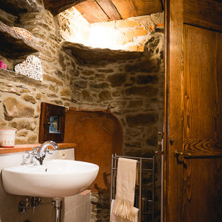 Foto de cuarto de baño campestre, pequeño, con suelo de ladrillo, lavabo suspendido y suelo naranja