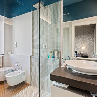 Immagine di una stanza da bagno design con ante lisce, ante bianche, doccia ad angolo, bidè, piastrelle bianche, piastrelle a mosaico, pareti bianche, pavimento in legno massello medio, lavabo a bacinella, pavimento marrone, doccia aperta, top marrone, un lavabo e mobile bagno sospeso