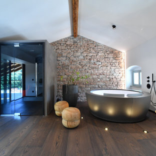 Idee per una stanza da bagno contemporanea con vasca freestanding, pareti bianche, parquet scuro e pavimento marrone