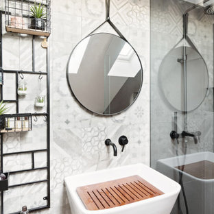 Foto di una stanza da bagno design con piastrelle grigie e lavabo sospeso