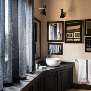 Esempio di una stanza da bagno boho chic con ante con riquadro incassato, ante nere, pareti beige e lavabo a bacinella