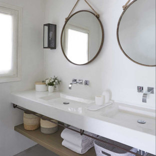 Foto di una stanza da bagno stile marino con pareti bianche, lavabo integrato, pavimento grigio e top bianco