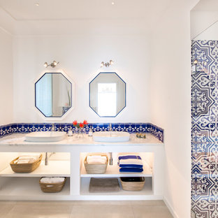 Idee per una stanza da bagno costiera con nessun'anta, ante bianche, piastrelle bianche, piastrelle blu, pareti bianche, lavabo a bacinella, pavimento beige e top grigio